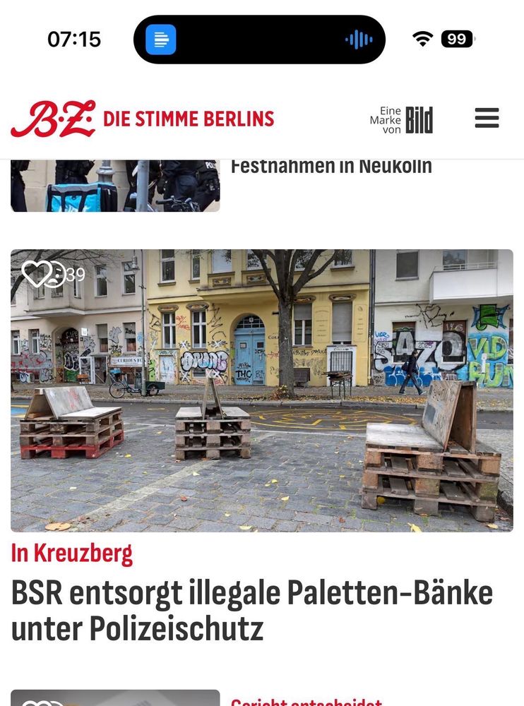 Screenshot BZ. Auf dem Bild Euro Paletten die zu drei Bänken zusammen gezimmert wurden die auf einer herbstlichen Straße stehen. 