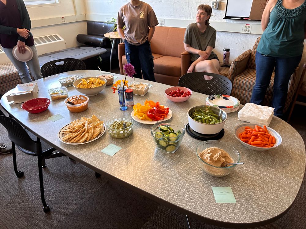 Hummus and veggies displayed on a table. 