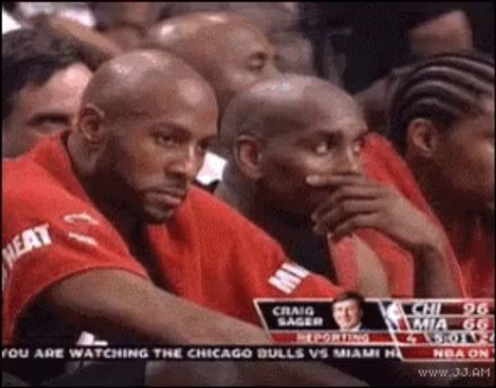 a group of men are watching a chicago bulls vs miami heat game .