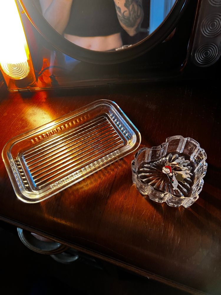 Two crystal trays one shaped like a heart and one that is ripped glass probably the bottom of a butter dish