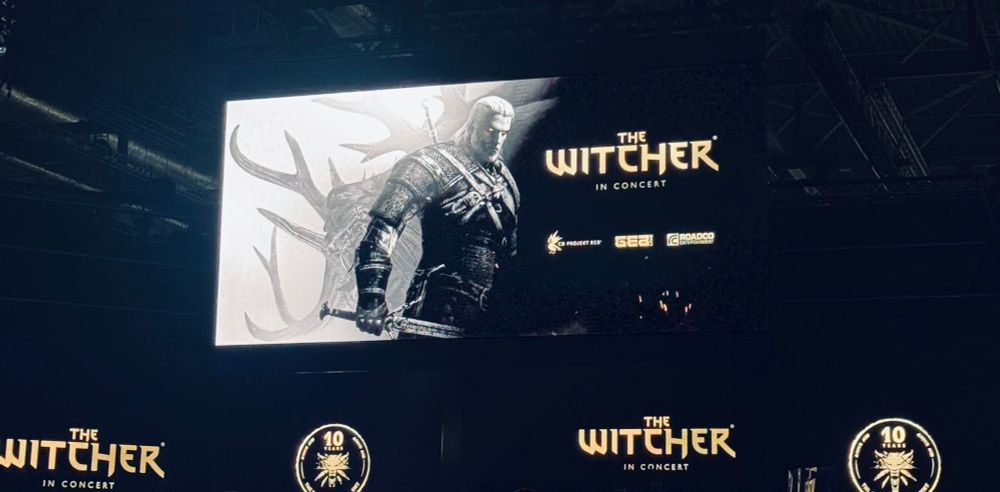 The Witcher in Concert banner on LED screens. There is also an image of the main character Geralt beside the text. In the background is a logo of the 10th anniversary of the Witcher 3