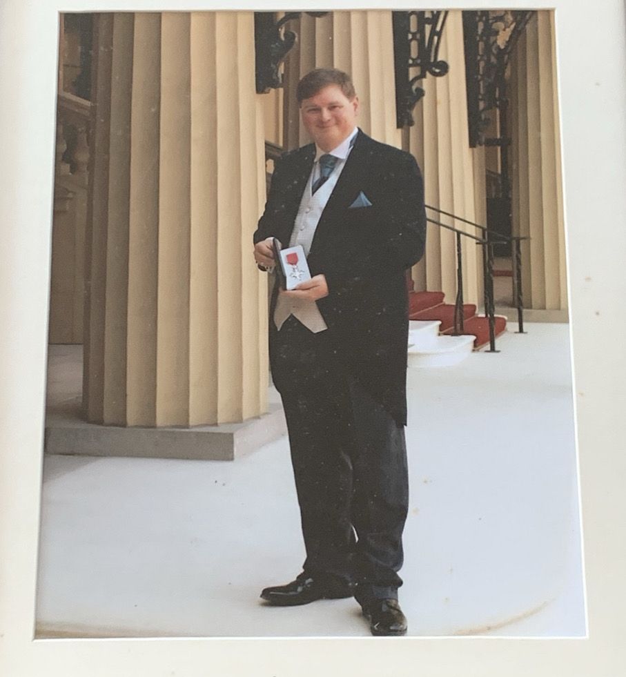 Me in morning suit holding my MBE 
