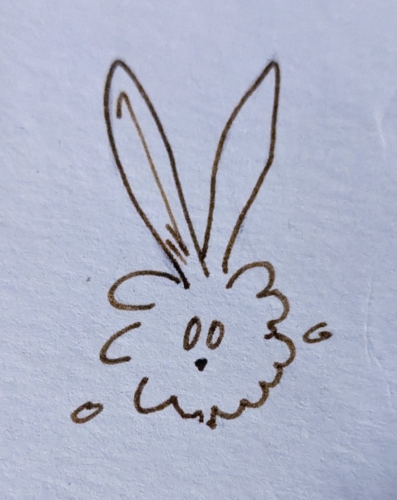 A simple cartoon doodle of what looks like a puffball with long ears, innocent eyes, and a small rabbit nose.