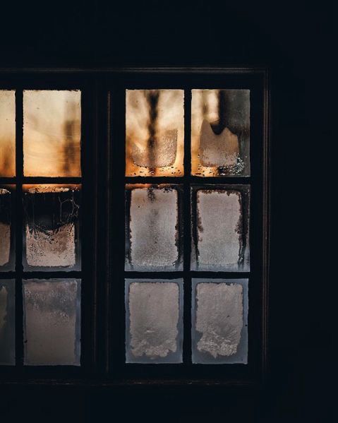 Photo of frozen windowpanes in double doors full of golden winter twilight 