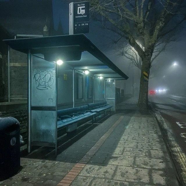 Photo of a bus stop on a foggy night 