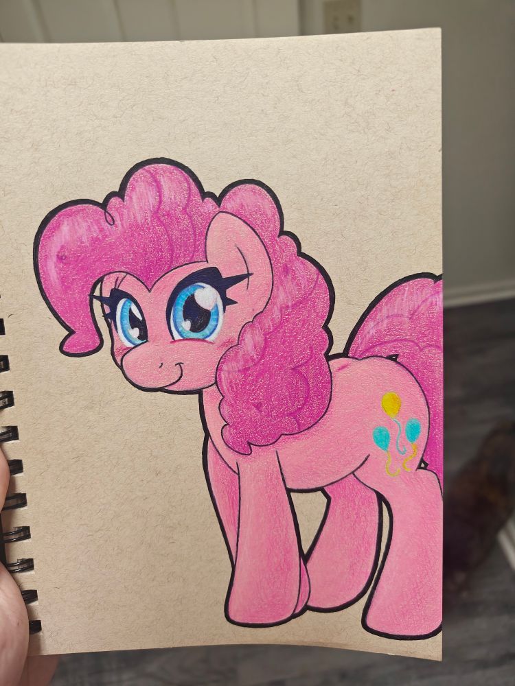 A Pinkie Pie looking at the viewer. Drawn in vibrant colored pencils and a black gel pen outline that is thicker on external lines. She's just kinda standing there with a fore leg slightly crossed behind the other. Also my cat is walking behind the picture of my notebook and I felt I couldn't just drop her out cause that's kinda funny.