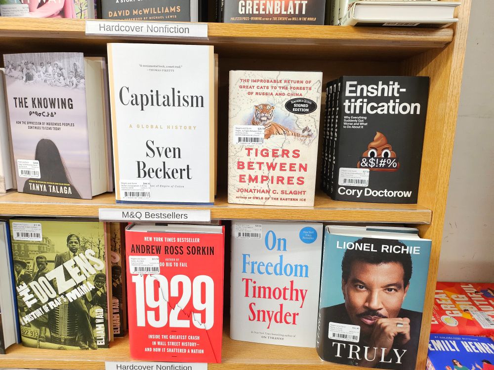 A line of books on a shelf, some more signed than others