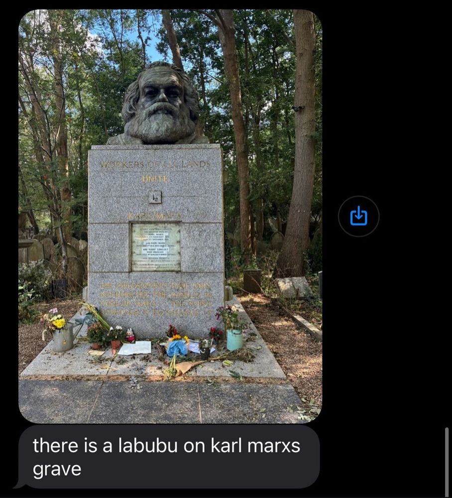 Textnachricht mit einem Bild vom Grab von Karl Marx. Dekoriert mit Blumen und Kerzen und einem Labubu. 
Darunter die Nachricht: 

there is a labubu on karl marxs grave



- gefunden bei Instagram
