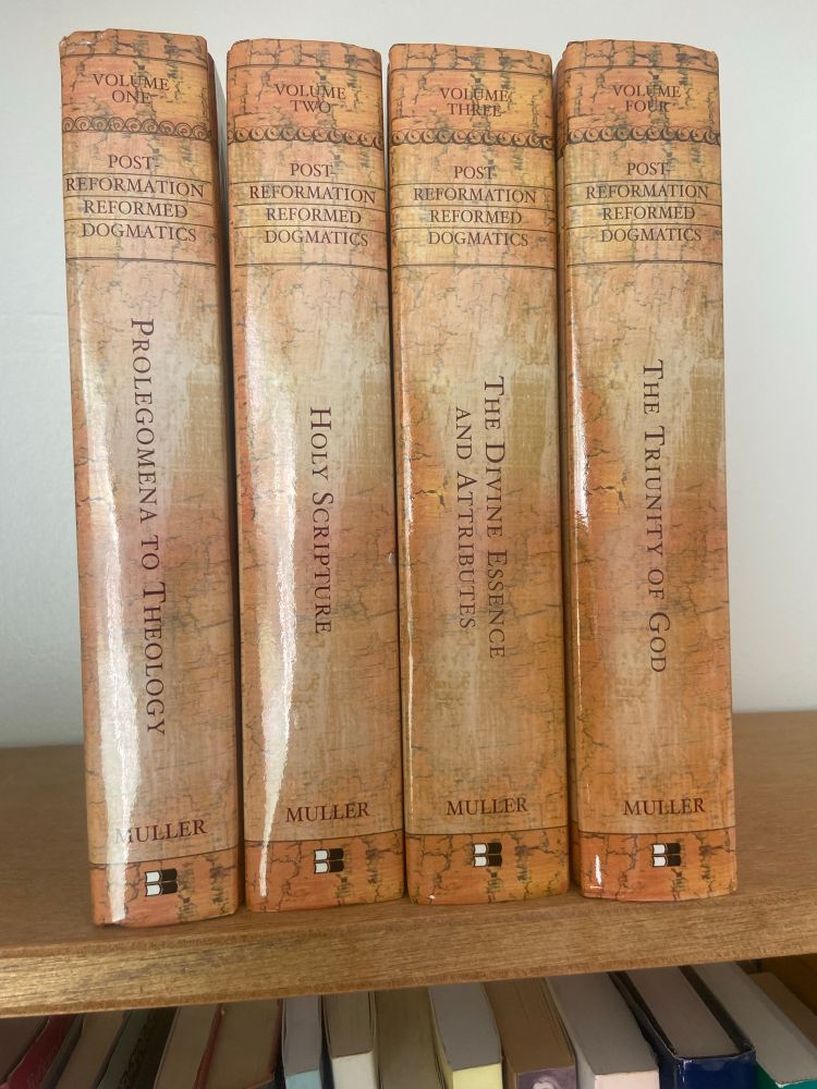 Richard Muller’s Post Reformation Reformed Dogmatics. 4 brown hardback books stood on their end in a row 