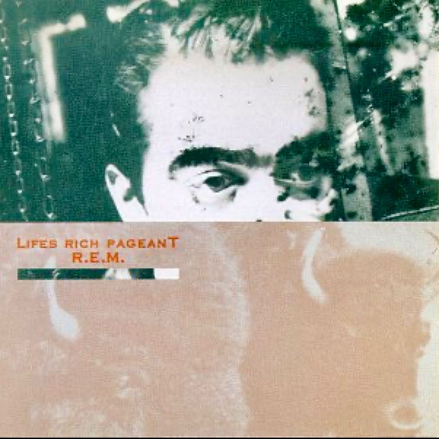 Cover art for the album Lifes Rich Pageant by R.E.M. Image is a photo collage; the upper half of the cover is a green-toned photo of the upper half of drummer Bill Berry’s face, and the bottom half of the cover is a pale sepia-toned photograph of buffaloes. It is a visual pun for the name Buffalo Bill.The band’s name and the album title are at left center in a small red serif typeface.