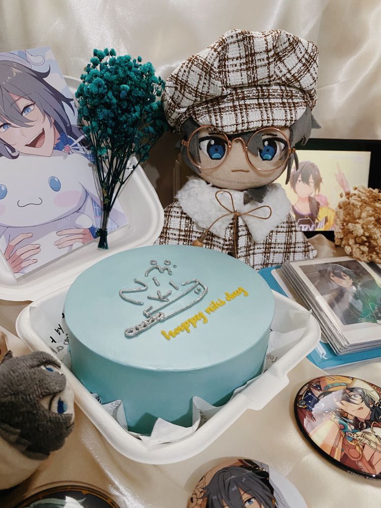 a cake with the greeting “happy niki day” surrounded by various type of niki merch
