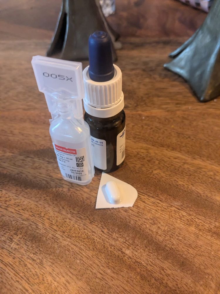 Two small medication bottles and a white capsule on a table. 