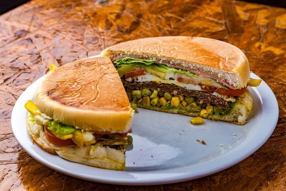 Xis, sanduíche gaúcho que consoste em um pao brioche prensado na chapa, recheado com: milho, ervilha, tomate, alface, ovo, queijo, presunto e carne 