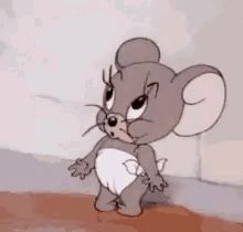 jerry from tom and jerry is standing next to a wall .