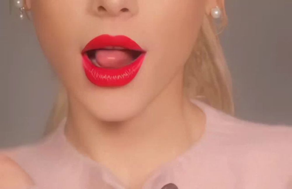 a close up of a woman 's mouth with red lipstick and her tongue sticking out