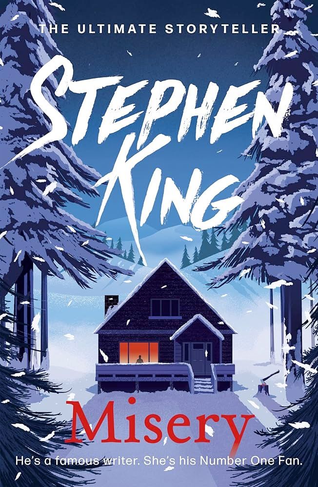The image is a book cover for Stephen King's "Misery." The title "Misery" is in large red text at the bottom. Above it, there is a tagline: "He’s a famous writer. She’s his Number One Fan." The author’s name, "Stephen King," is prominently displayed in bold white lettering near the top, with the phrase "The Ultimate Storyteller" above it.

The illustration shows a snow-covered cabin surrounded by tall, dark pine trees under a deep blue night sky. A figure can be seen silhouetted in a warmly lit window, adding a sense of isolation and suspense. Snowflakes are falling throughout the scene, emphasizing the cold and remote setting.