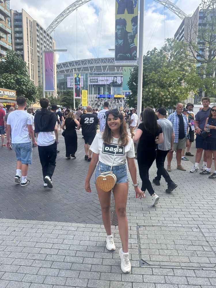 Me at oasis outside Wembley stadium. I am wearing an oasis t shirt and blue shorts 