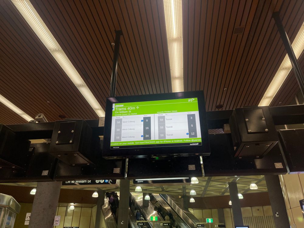A digital display with Tram departure times in a train station. A Web Browser dialog is open in the corner of the screen.