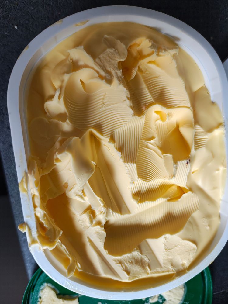 A tub of Clover spread that's been hacked to bits 