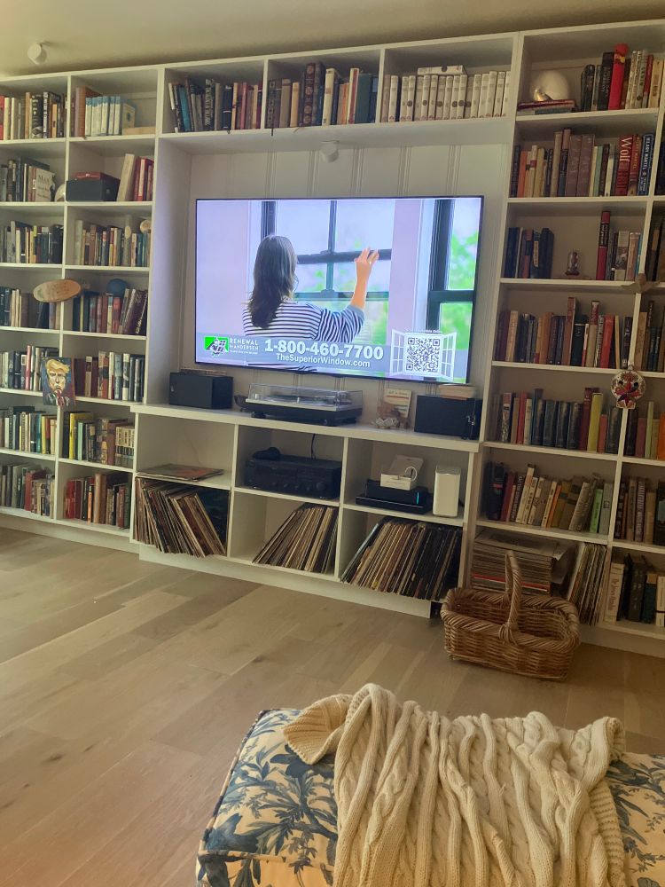 Bookcases with vinyl and books and TV monitor. 