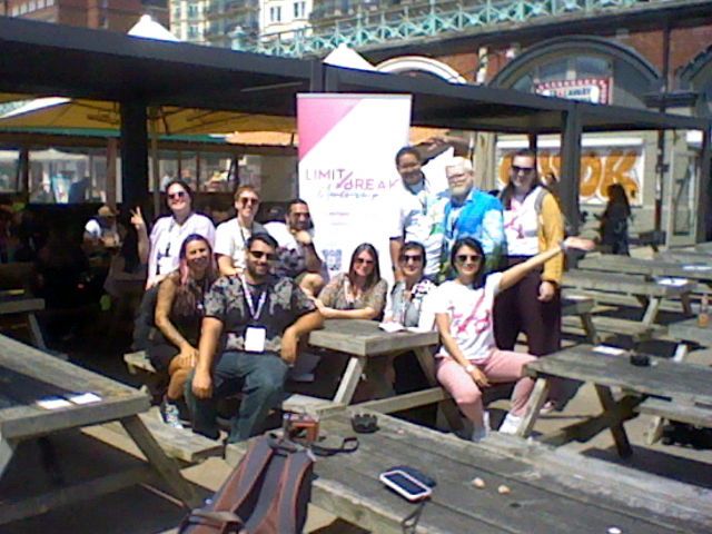 Limit Break committee posing in front of a white and pink Limit Break pop up banner