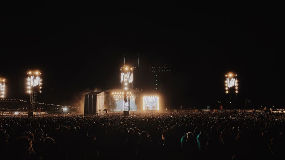 Zoomed out photo of the Download festival main stage taken from the crowd. Three large screens show the Korn band logo.