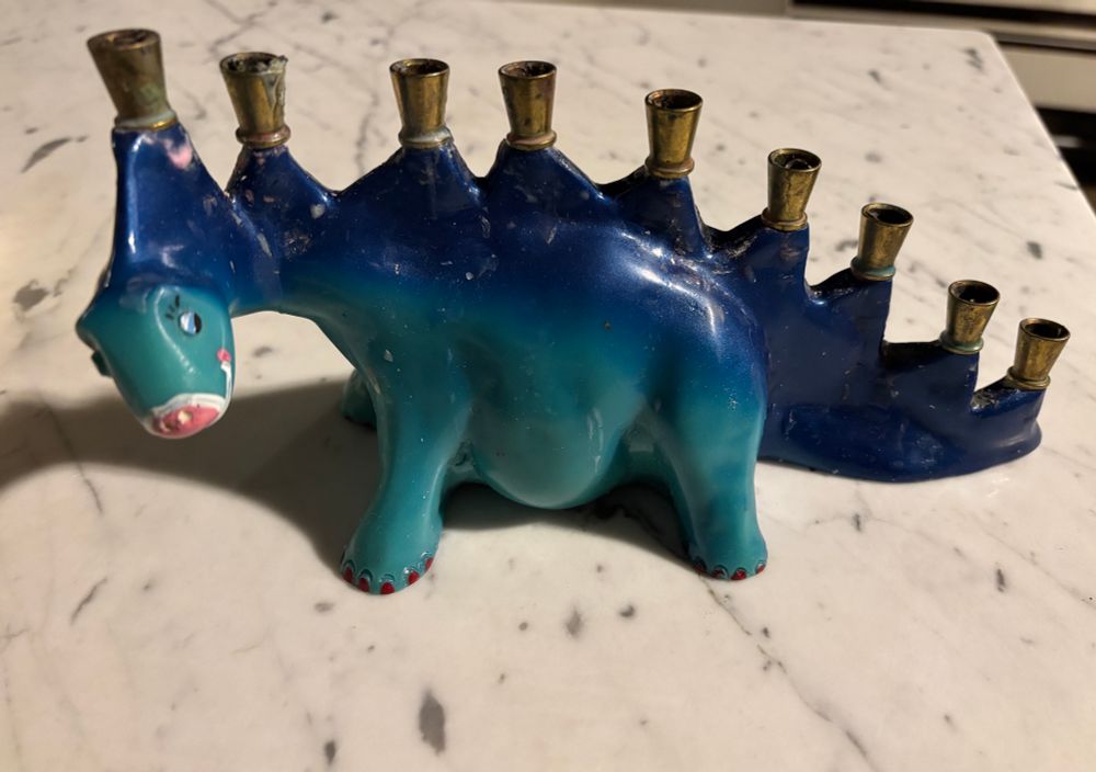 A cartoony blue stegosaurus menorah 