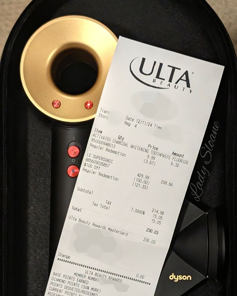 A new Dyson Hair Dryer with a receipt laying on top of it. The total is $230.03.