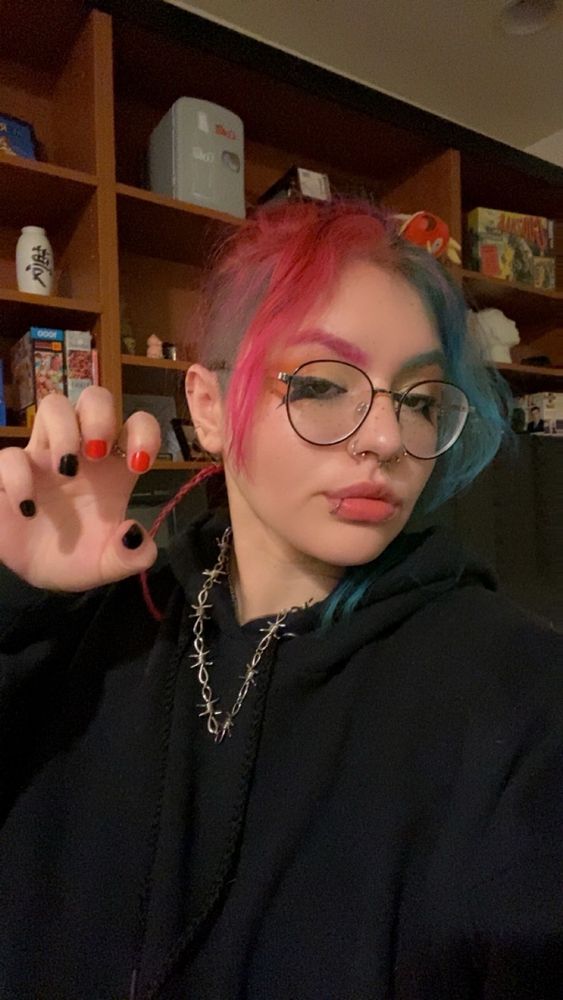 picture of me, agender dogthing, showing off my nails that are painted black and red!