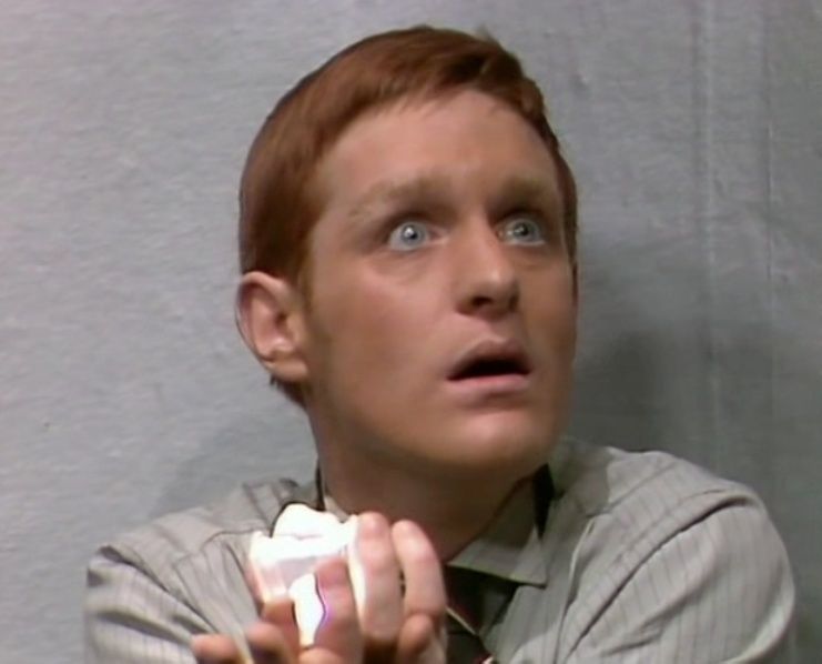 Frightened man with red hair holding a glowing crystal 
From Dr Who