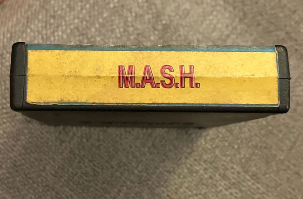  End label view. Plain red text with black outline that says “M.A.S.H.” on a solid yellow field. The red printing is offset in error by a hair