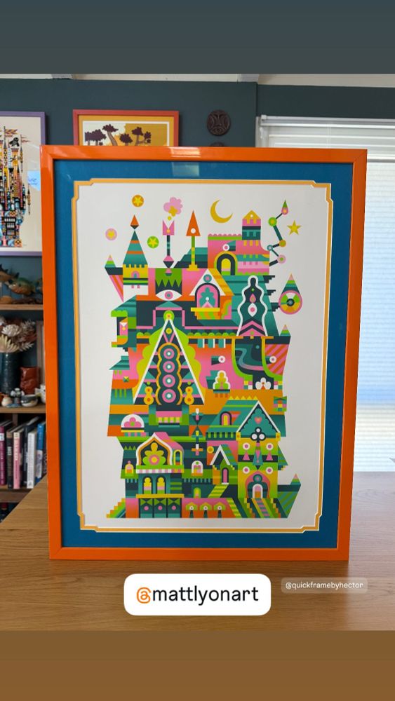 Print of my Carnival House artwork in an orange frame with blue and yellow mount