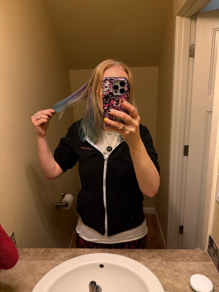 Blonde girl showing purple and teal hairstyle