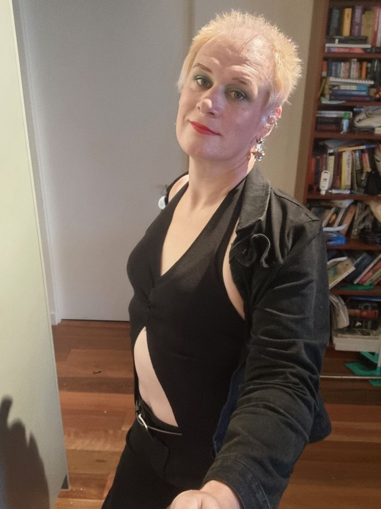A 43 year old trans woman in a black top that shows off her belly