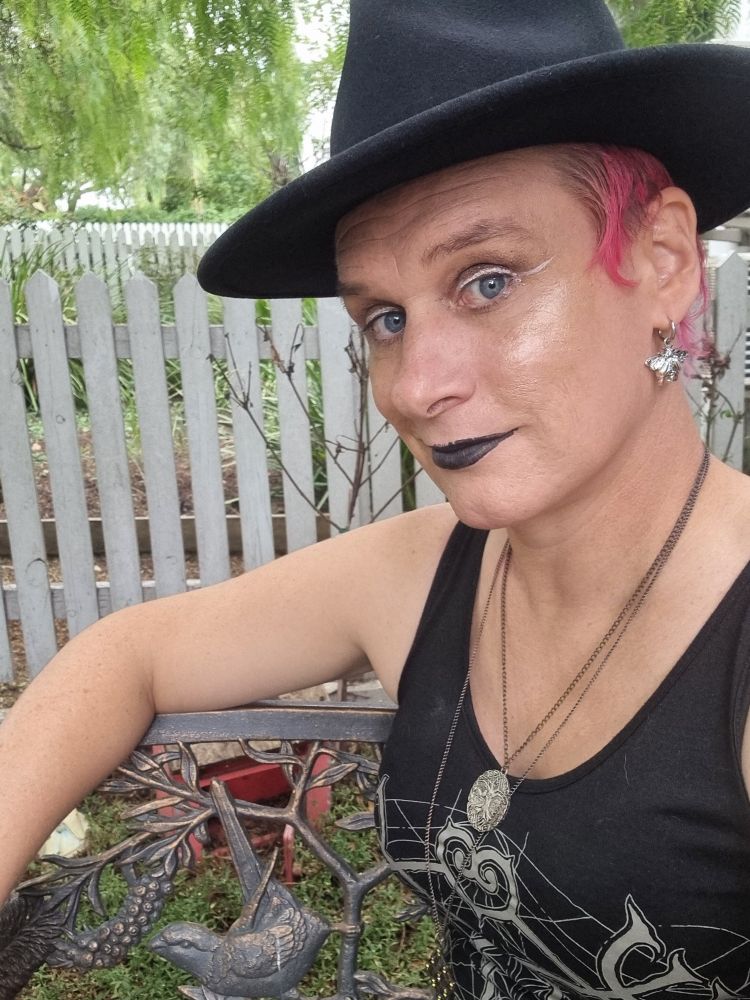 A trans woman in a hat. 