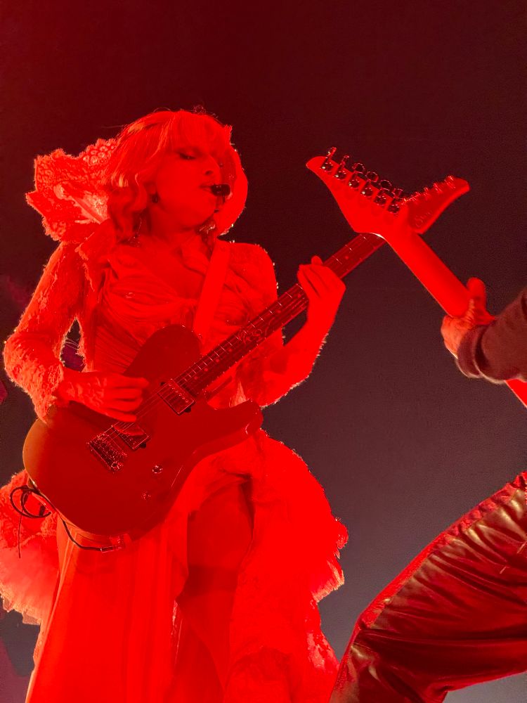 Concert pic of lady Gaga rocking out with a guitar.