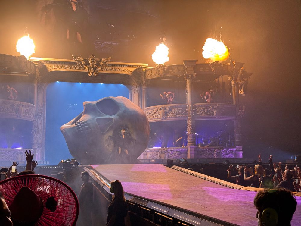 A series of concert pics. Lady Gaga is in front of a giant skull.