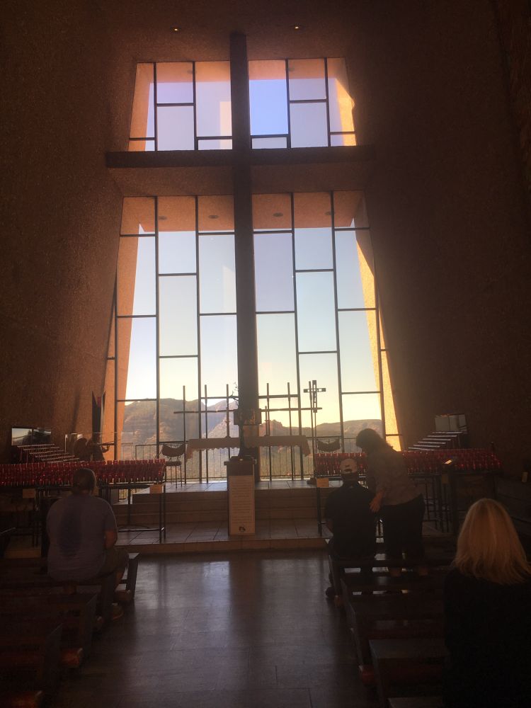 The nave of the chapel, with windows looking out over the red rock desert of the Coconino National Forest.