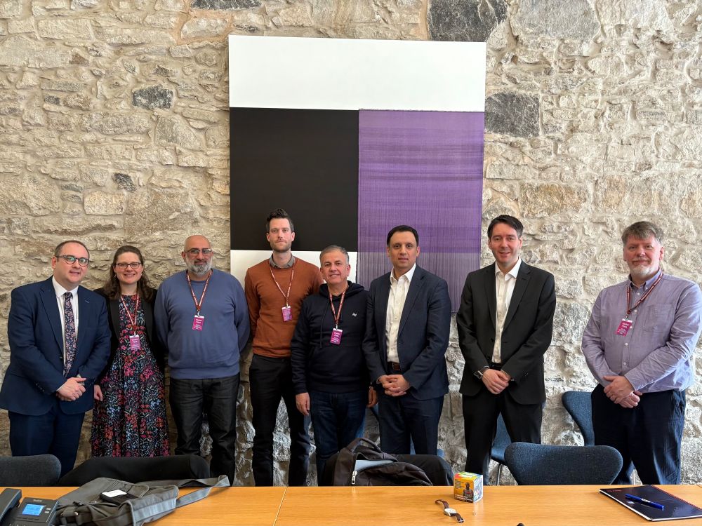 Paul O’Kane standjng beside his Scottish Labour colleagues and representatives of faith based groups in the Scottish Parliament.