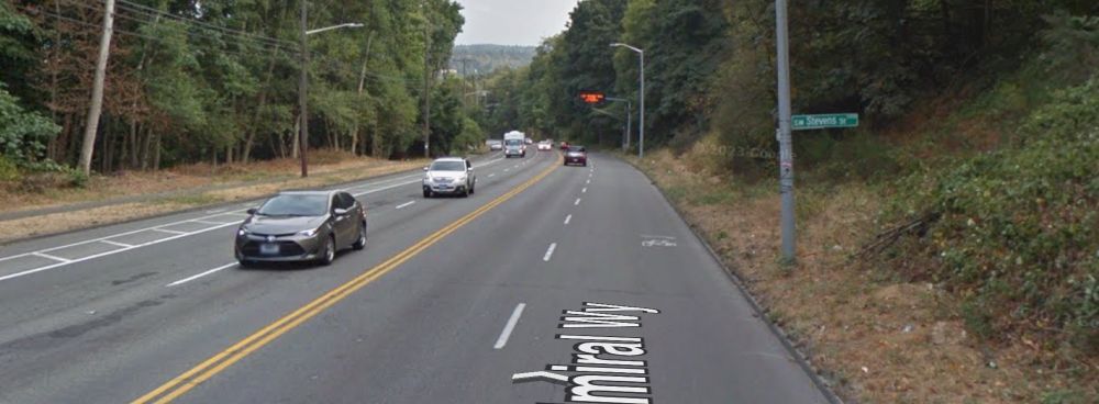 Street view showing admiral Way as it exist today with four lanes of high-speed traffic. A small sharrow can be seen on the road