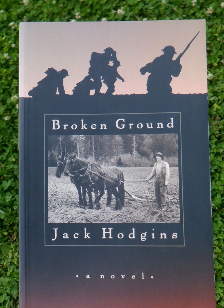 Photo of the cover of the novel, Broken Ground, by Jack Hodgins. In the centre is a black and white photo from the Courtenay and District Museum, Vancouver Island. It shows a person holding the reins of two horses that are hitched to a plough. At the top of the cover is a silhouette of running soldiers based on a photo of Canadian troops in France, 1906 by William Ivor Castle. 