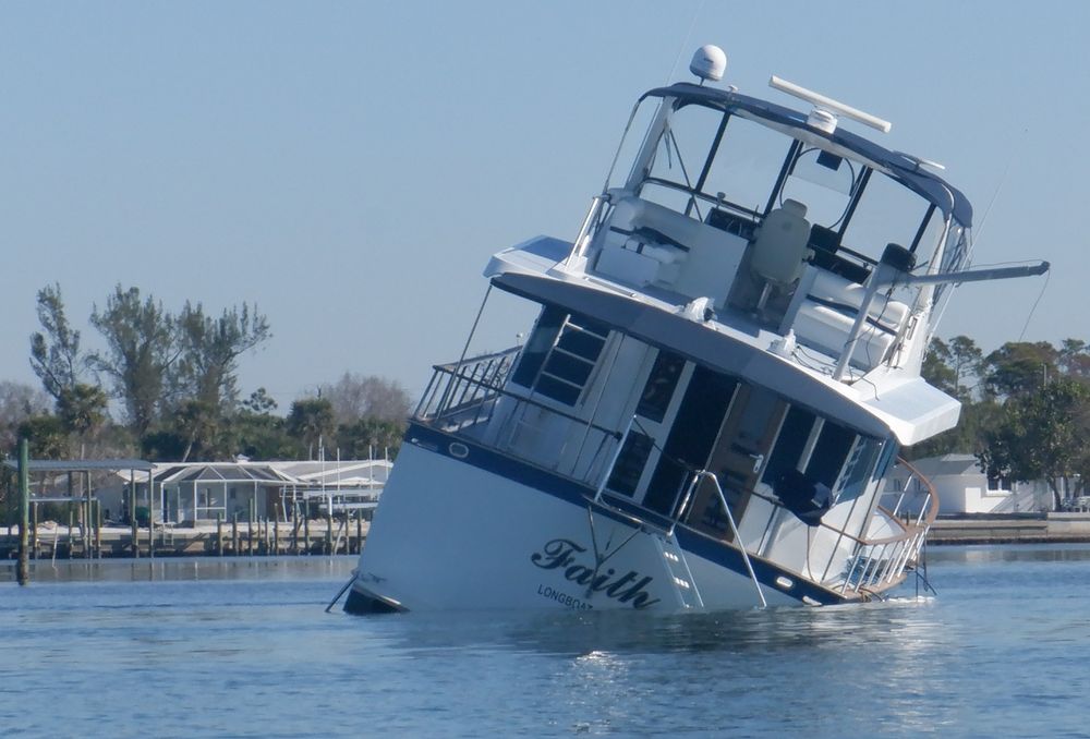 Photo of a half-sunken boat that is named Faith. 