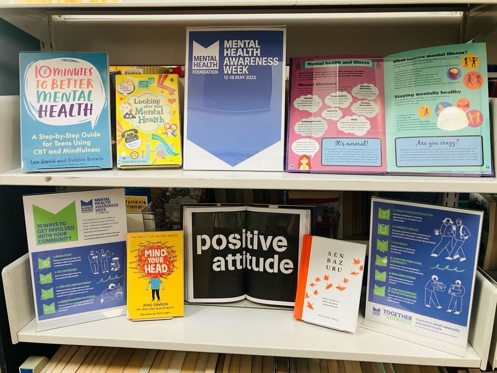A display over two shelves in the library, with a poster for Mental Health Awareness Week. Books include Looking After Your Mental Health and Ten Minutes to Better Mental Health 