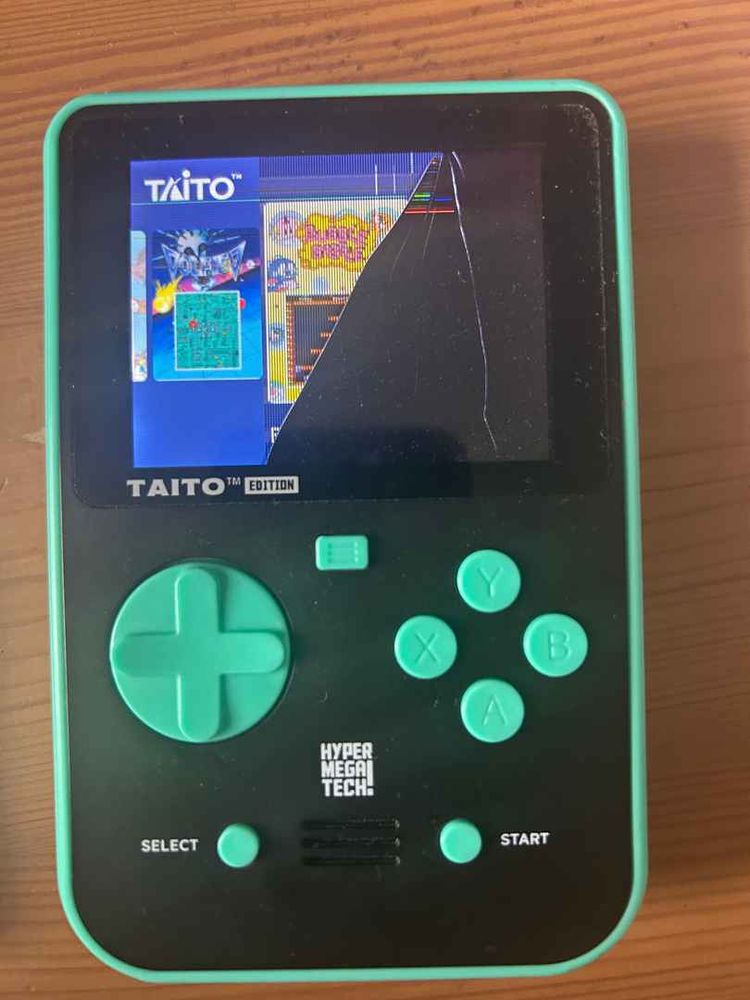 A photo of the Taito version of the Hyper Mega Tech Evercade handheld with a broken screen…