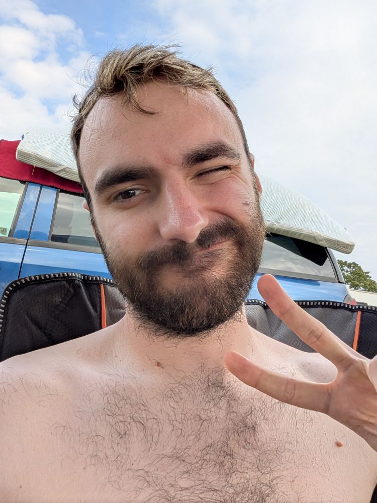 Shirtless shelfie throwing up the peace sign and one eye closed in a "winking" fashion