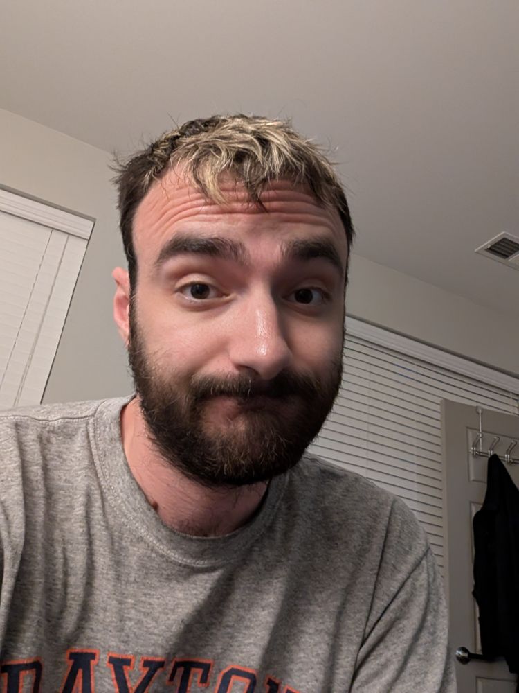 Selfie in my apartment wearing a gray shirt with tousled hair *Inner turmoil rattling my brain*