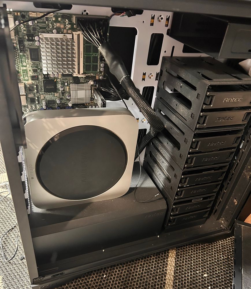 A computer case with a MicroItx mother board and a stack of 8 3.5 hard drives on the right. And a Mac mini to control it. 