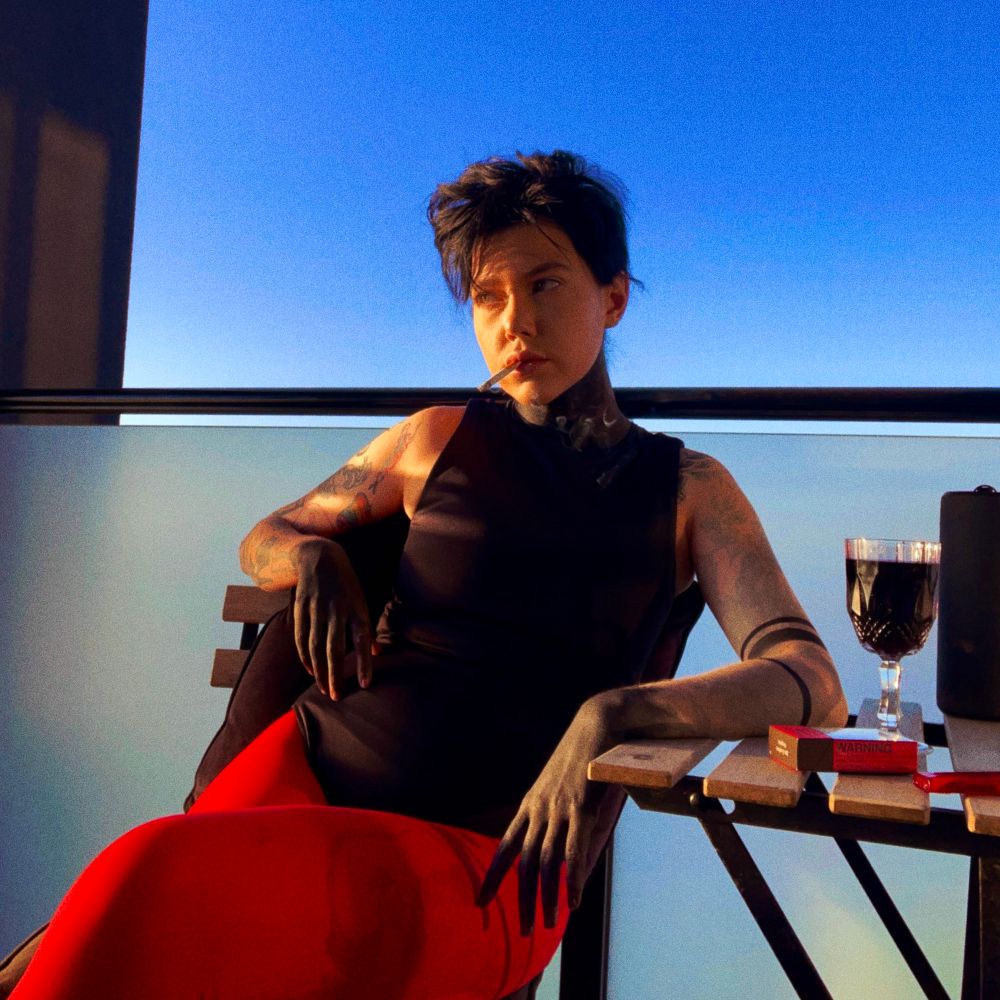 me sitting on my balcony in red tights/bodysuit tyler cosplay w my legs crossed and a cig hanging out my mouth with decidedly limp wrists 