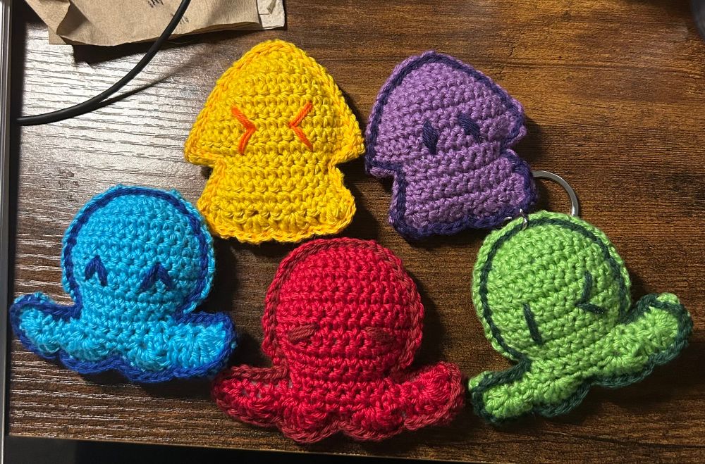 Two crochet inkling swim form keychains and three octoling swim form keychains