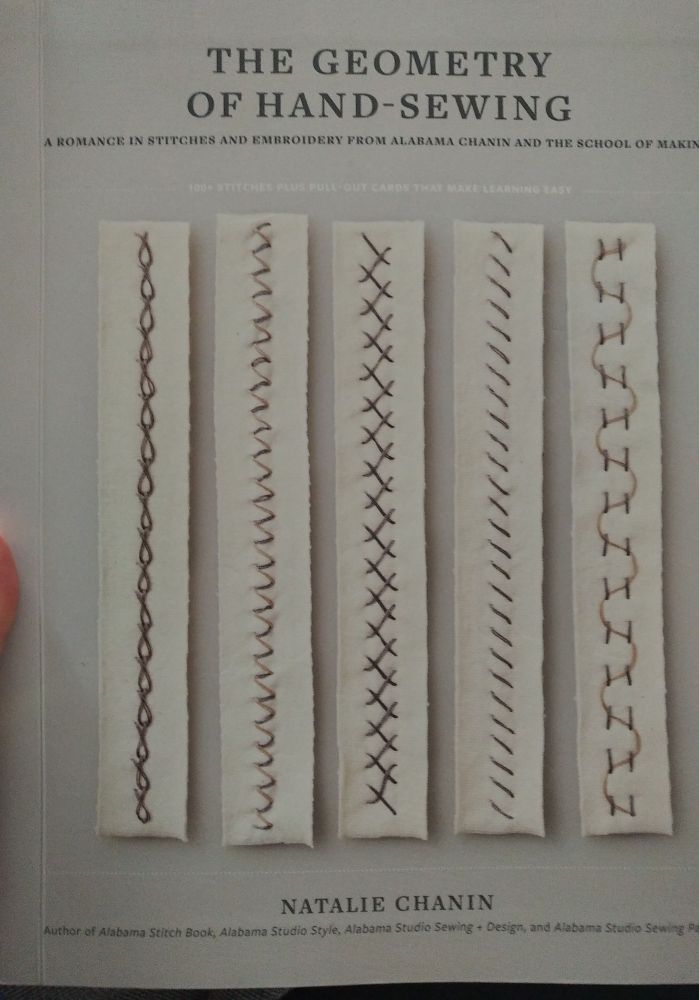 Front cover of Natalie Chanin's The Geometry of Hand-Sewing
"A romance in stitches and embroidery from Alabama Chanin and the School of Making
100+ stitches + pull-out cards that make learning easy.
Author of Alabama Stitch Book, Alabama Studio Style, Alabama Studio Sewing + Design, and Alabama Studio Sewing Patterns."

 Cover image are 5 vertical samples of stitches on narrow strips of white fabric.

A decorative multi-stranded chain stitch in dove grey.
A two-tone zigzag with dove grey and pale pink stitches alternating.
An occset cross-stitch with the "X" crosses formed off-center, alternating sides, in grey.
A simple, repeated, diagonal stitch in slanted lines of grey.
A loose couching stitch with a pale pink threaded in wide, sweeping "S" curves between paired vertical stitches of grey.